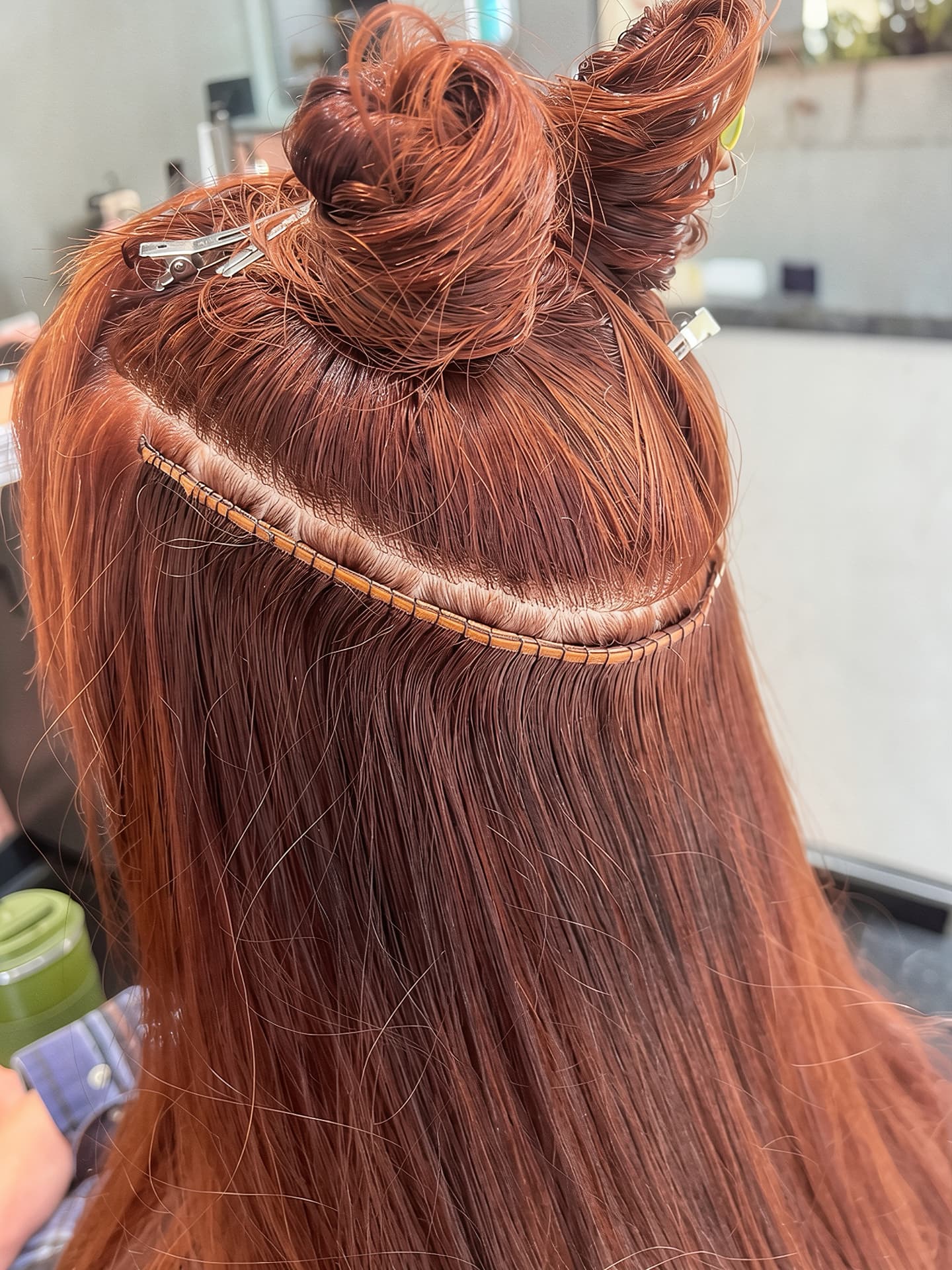 Hand-tied weft extension row installed in copper red hair at Mill & Mane Hair Co., Tipp City